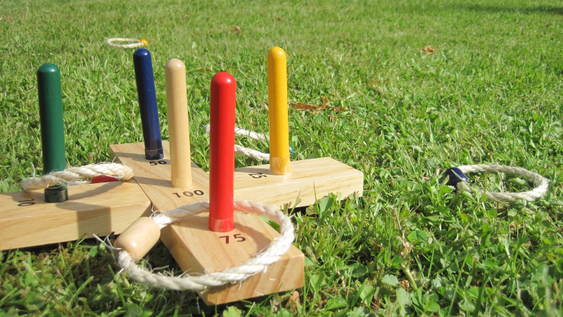 Ring toss game on green grass.